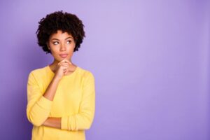 woman-looks-thoughtful-against-purple-background